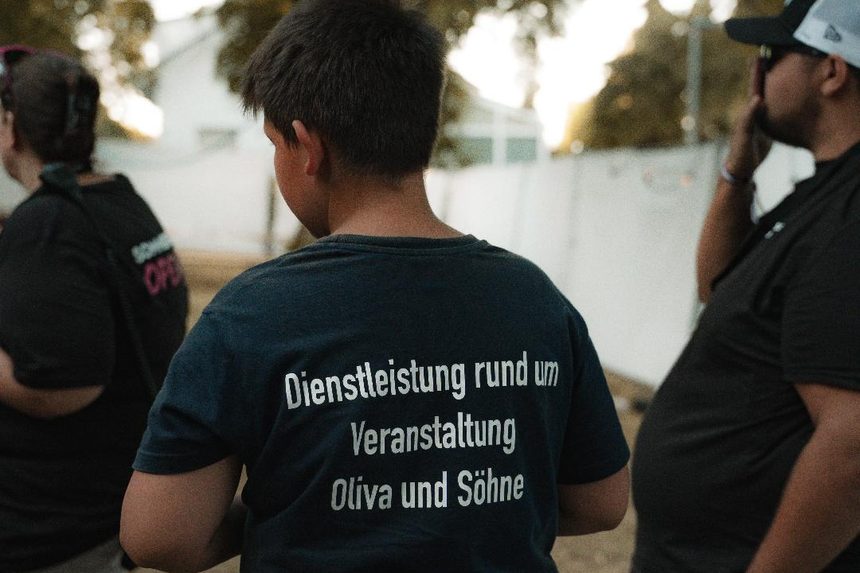 Mitarbeitershirt mit dem Aufdruck „Dienstleistung rund um Veranstaltung, Oliva und Söhne“